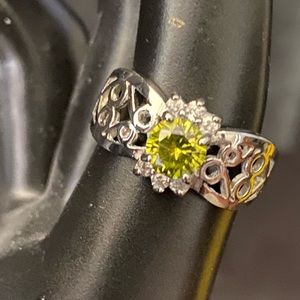 Silver tone filigree ring with peridot colored rhinestone
